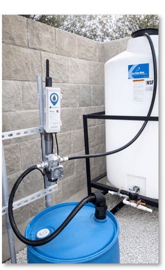 WellAware Scout device mounted on a DIN rail with hoses connected to a storage tank.